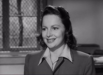Movie still from “The Snake Pit” (1948), directed by Anatole Litvak – An old photo of a woman smiling for the camera; Close Up shot, High angle