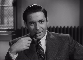 Movie still from “The Snake Pit” (1948), directed by Anatole Litvak – A man wearing a suit and tie holding a pipe; Close Up shot, High angle