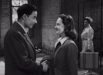 Movie still from “The Snake Pit” (1948), directed by Anatole Litvak – A man and a woman shaking hands in a black and white photo; Medium shot, Over the shoulder angle