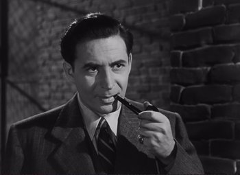 Movie still from “The Snake Pit” (1948), directed by Anatole Litvak – A man in a suit and tie holding a pipe in his mouth; Close Up shot, High angle