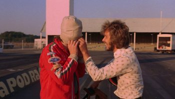 Movie still from “The Song Remains the Same” (1976), directed by Peter Clifton – Two men are fixing their hoods on each other's head; Close Up shot, Over the shoulder angle