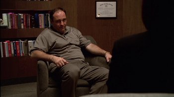 Movie still from “The Sopranos” (1999), created by David Chase – A man sitting in a chair in front of a person; Medium shot, Over the shoulder angle