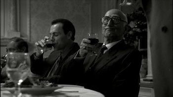 Movie still from “The Sopranos” (1999), created by David Chase – Two men sitting at a dinner table drinking wine; Medium shot, Low angle