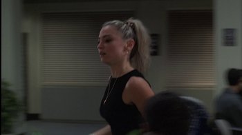 Movie still from “The Sopranos” (1999), created by David Chase – A woman with a ponytail is walking in a room; Close Up shot, Over the shoulder angle