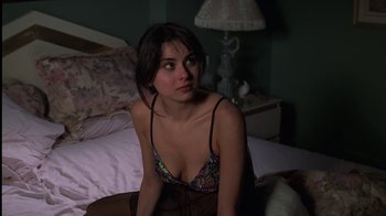 Movie still from “The Sopranos” (1999), created by David Chase – A woman sitting on top of a bed wearing lingerie; Close Up shot, High angle