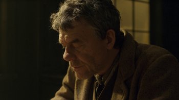 Movie still from “Anne with an E” (2017), created by Moira Walley-Beckett – An older man wearing a brown jacket and a neck tie; Close Up shot, Low angle
