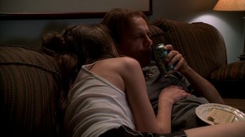 Movie still from “The Sopranos” (1999), created by David Chase – A man and a woman are sitting on a couch drinking a beer; Medium shot, High angle