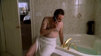 Movie still from “The Sopranos” (1999), created by David Chase – A man in a towel talking on a phone; Medium shot, Low angle
