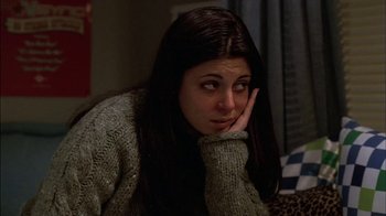 Movie still from “The Sopranos” (1999), created by David Chase – A woman sitting on a couch with her hand on her face; Close Up shot, High angle