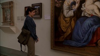 Movie still from “The Sopranos” (1999), created by David Chase – A woman walking in front of a painting in a museum; Medium shot, Over the shoulder angle