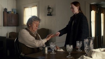 Movie still from “Anne with an E” (2017), created by Moira Walley-Beckett – An older woman sitting at a table with a young girl; Medium shot, Over the shoulder angle