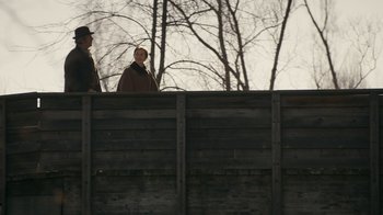 Movie still from “Anne with an E” (2017), created by Moira Walley-Beckett – Two people standing on a fence looking at each other; Wide shot, Low angle