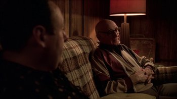 Movie still from “The Sopranos” (1999), created by David Chase – Two men sitting on a couch in a living room; Medium shot, Over the shoulder angle