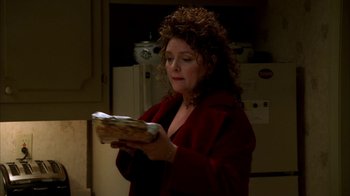 Movie still from “The Sopranos” (1999), created by David Chase – A woman in a red jacket holding a piece of bread; Close Up shot, High angle