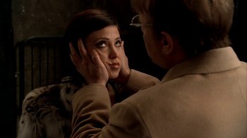 Movie still from “The Sopranos” (1999), created by David Chase – A woman looking in a mirror while holding her hands to her face; Close Up shot, Over the shoulder angle