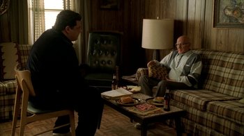 Movie still from “The Sopranos” (1999), created by David Chase – Two men sitting on a couch in a living room; Wide shot, High angle
