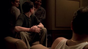 Movie still from “The Sopranos” (1999), created by David Chase – A man sitting on a couch next to another man; Medium shot, Over the shoulder angle