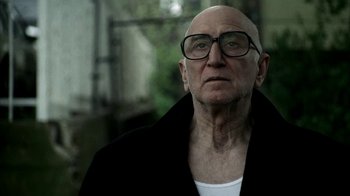 Movie still from “The Sopranos” (1999), created by David Chase – An older man wearing glasses and a black jacket; Close Up shot, Low angle
