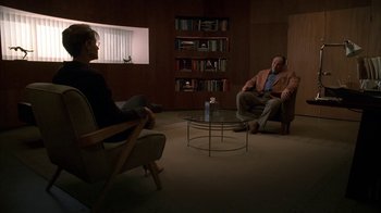 Movie still from “The Sopranos” (1999), created by David Chase – A man and a woman are sitting in a living room; Wide shot, High angle