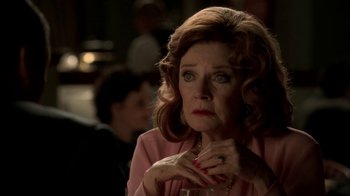 Movie still from “The Sopranos” (1999), created by David Chase – An older woman is sitting in front of a group of people; Close Up shot, Over the shoulder angle