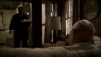 Movie still from “The Sopranos” (1999), created by David Chase – A man sitting on a couch in front of a mirror; Wide shot, Over the shoulder angle