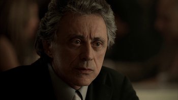 Movie still from “The Sopranos” (1999), created by David Chase – An older man in a suit and tie looking at the camera; Close Up shot, Low angle