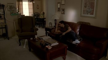 Movie still from “The Sopranos” (1999), created by David Chase – Two people are sitting on a couch in a living room; Wide shot, High angle