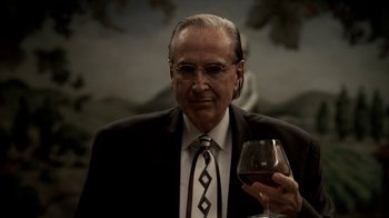 Movie still from “The Sopranos” (1999), created by David Chase – An older man holding a glass of red wine; Close Up shot, Low angle
