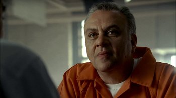 Movie still from “The Sopranos” (1999), created by David Chase – An older man in an orange prison uniform looking into the distance; Close Up shot, Low angle