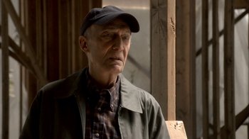 Movie still from “The Sopranos” (1999), created by David Chase – An older man wearing a hat and a jacket; Close Up shot, Over the shoulder angle