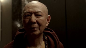 Movie still from “The Sopranos” (1999), created by David Chase – An older man with a bald head wearing a monk's outfit; Close Up shot, Low angle