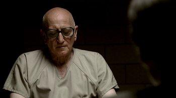 Movie still from “The Sopranos” (1999), created by David Chase – An old man wearing glasses and a tan shirt; Close Up shot, Over the shoulder angle