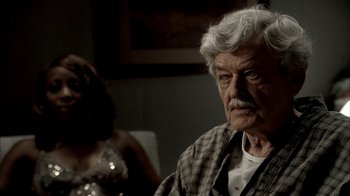 Movie still from “The Sopranos” (1999), created by David Chase – An older man sitting in front of a woman; Close Up shot, Over the shoulder angle