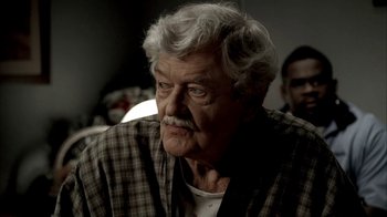 Movie still from “The Sopranos” (1999), created by David Chase – An older man with a mustache and a beard; Close Up shot, Over the shoulder angle