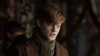Movie still from “Anne with an E” (2017), created by Moira Walley-Beckett – A young man wearing a brown jacket and a scarf; Close Up shot, Low angle