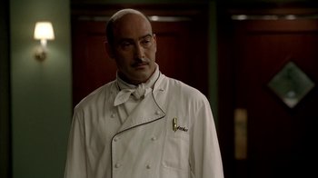 Movie still from “The Sopranos” (1999), created by David Chase – A man in a chef's outfit standing in front of a door; Close Up shot, Low angle
