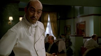 Movie still from “The Sopranos” (1999), created by David Chase – A man in a chef's outfit standing in front of other people; Close Up shot, Low angle