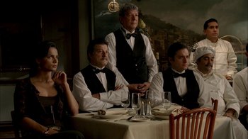 Movie still from “The Sopranos” (1999), created by David Chase – A group of people sitting at a table with wine glasses; Medium shot, Over the shoulder angle