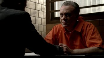 Movie still from “The Sopranos” (1999), created by David Chase – An older man in an orange shirt talking to a younger man in an orange shirt; Close Up shot, Over the shoulder angle