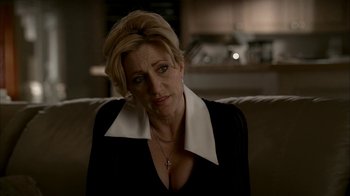 Movie still from “The Sopranos” (1999), created by David Chase – A woman sitting on top of a couch in a living room; Close Up shot, Over the shoulder angle