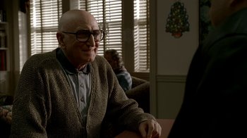 Movie still from “The Sopranos” (1999), created by David Chase – An older man sitting at a table in front of a computer; Medium shot, Over the shoulder angle