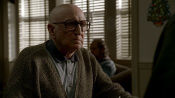 Movie still from “The Sopranos” (1999), created by David Chase – An older man wearing glasses and a sweater; Close Up shot, Low angle
