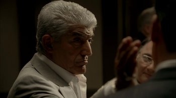 Movie still from “The Sopranos” (1999), created by David Chase – An older man in a white suit sitting in front of a mirror; Close Up shot, Over the shoulder angle