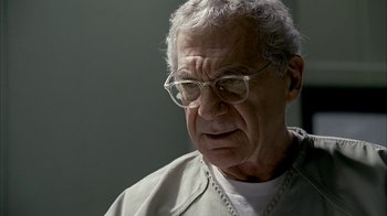 Movie still from “The Sopranos” (1999), created by David Chase – An older man wearing glasses and a white shirt; Close Up shot, Over the shoulder angle