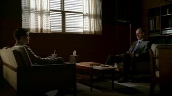 Movie still from “The Sopranos” (1999), created by David Chase – Two people sitting on a couch in front of a window; Wide shot, Over the shoulder angle