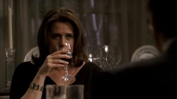 Movie still from “The Sopranos” (1999), created by David Chase – A woman holding a wine glass in front of her face; Close Up shot, Over the shoulder angle