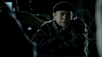 Movie still from “The Sopranos” (1999), created by David Chase – An older man wearing a leather jacket and a hat; Close Up shot, Low angle