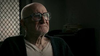 Movie still from “The Sopranos” (1999), created by David Chase – An old man wearing glasses and a sweater; Close Up shot, Over the shoulder angle