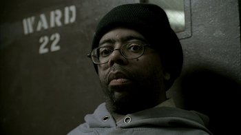 Movie still from “The Sopranos” (1999), created by David Chase – A person wearing glasses and a hat; Close Up shot, Low angle