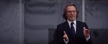 Movie still from “The Space Between Us” (2017), directed by Peter Chelsom – A man in a suit and tie standing in front of a building; Close Up shot, Over the shoulder angle